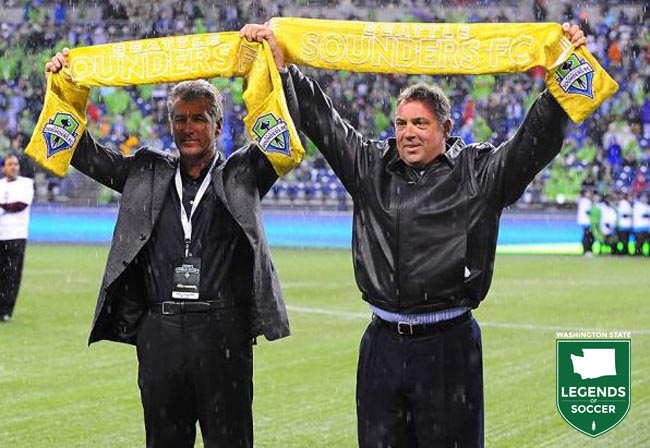 Tacoma and NASL Sounders legends Jeff Stock, left, and Mark Peterson raise their golden scarves prior to the first MLS league match vs. Portland. (Sounders FC photo)