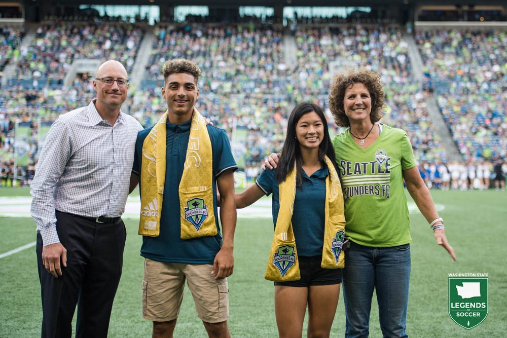 Kasey Keller and Michelle Akers present the Golden Scarf to two representative Washington Youth Soccer players, marking the organization's 50th anniversary. (Courtesy Sounders FC)